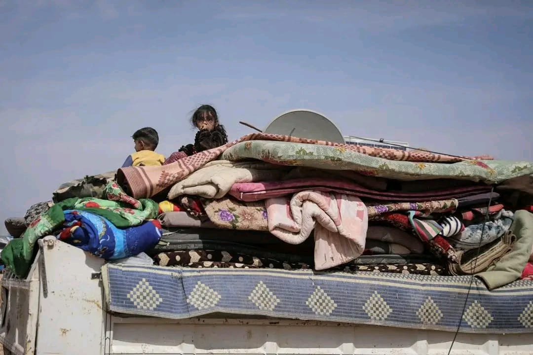 A 10-month old child is eating peanut paste while being tended to by an IRC nutrition officer in Yemen