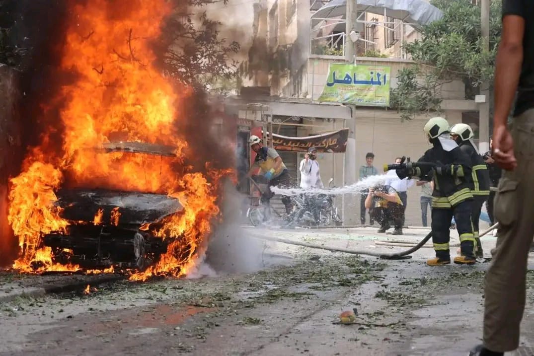 A man with his arm around a woman, both looking into the camera and smiling